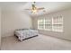 Bedroom featuring a ceiling fan, carpeted floor, and multiple bright windows at 310 Hammersmith Dr, Suwanee, GA 30024