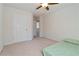 Neutral bedroom with ceiling fan, a window with blinds, carpeted floors, and closet space at 310 Hammersmith Dr, Suwanee, GA 30024