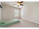 Neutral bedroom featuring a ceiling fan, carpeted floors, and a window with blinds and closet space at 310 Hammersmith Dr, Suwanee, GA 30024