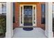 Close-up of a black front door framed by sidelights and white pillars in a brick facade at 310 Hammersmith Dr, Suwanee, GA 30024