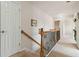 Upstairs hallway with wood railing and carpet flooring at 310 Hammersmith Dr, Suwanee, GA 30024
