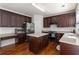 Bright kitchen boasts an island, stainless appliances, and attractive dark-stained wood floors at 310 Hammersmith Dr, Suwanee, GA 30024