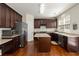 Well-equipped kitchen with dark wood cabinets, stainless steel appliances, and central island at 310 Hammersmith Dr, Suwanee, GA 30024