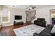 Bright living room with hardwood floors, featuring a comfortable sofa and modern TV setup at 310 Hammersmith Dr, Suwanee, GA 30024