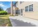 Backyard patio with windows and door leading into the home and some grass on the side at 310 Hammersmith Dr, Suwanee, GA 30024