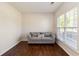Cozy sitting area with natural light, hardwood floors, and comfortable gray sofa at 310 Hammersmith Dr, Suwanee, GA 30024