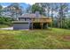 Backyard featuring an elevated wooden deck, large yard, and mature trees at 3232 Watson Mill Dr, Loganville, GA 30052