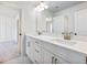Bathroom vanity featuring double sinks, white cabinets with elegant gold hardware and Quartz countertops at 4191 Hosch Reserve Dr, Buford, GA 30519