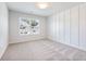 A well lit and airy bedroom with a feature wall, large windows, and neutral carpeting at 4191 Hosch Reserve Dr, Buford, GA 30519