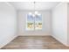 Bright dining room with hardwood floors and a modern light fixture near a window at 4191 Hosch Reserve Dr, Buford, GA 30519