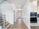 Inviting hallway with hardwood floors, staircase, wainscoting, and convenient access to the kitchen at 4191 Hosch Reserve Dr, Buford, GA 30519