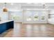 Open-concept living room with hardwood floors, ceiling fan, ample windows, and access to outdoor views at 4191 Hosch Reserve Dr, Buford, GA 30519