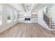 Stylish living room featuring hardwood floors, fireplace, built-in shelving, staircase, and bright windows at 4191 Hosch Reserve Dr, Buford, GA 30519