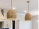 Kitchen pendants: Rattan pendant lights add texture and warmth above the kitchen island and adjacent cabinets at 4191 Hosch Reserve Dr, Buford, GA 30519