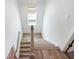 Bright staircase with wood-look flooring and modern light fixture at 4191 Hosch Reserve Dr, Buford, GA 30519