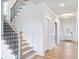 Elegant staircase with modern black railings and oak steps near the front door at 4191 Hosch Reserve Dr, Buford, GA 30519