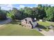 Aerial view showcasing this brick home's curb appeal, long driveway, and lush, green lawn at 423 Blackbird Way, Hampton, GA 30228