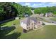 Aerial view of a brick front home with a lush lawn and landscaped garden in a friendly neighborhood at 423 Blackbird Way, Hampton, GA 30228