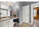 Bright bathroom with a single vanity, large mirror and entry to a walk-in closet at 423 Blackbird Way, Hampton, GA 30228