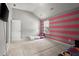 Spacious bedroom with vaulted ceiling, pink accent wall, and large area rug at 423 Blackbird Way, Hampton, GA 30228
