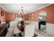 Elegant dining room features a rustic wooden table and ornate chandelier with views of the kitchen at 423 Blackbird Way, Hampton, GA 30228