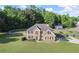 Charming two-story brick home with a well-manicured lawn and mature trees at 423 Blackbird Way, Hampton, GA 30228