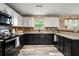 Updated kitchen featuring dark lower cabinets, white upper cabinets and granite counters at 423 Blackbird Way, Hampton, GA 30228