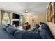 Cozy living room with fireplace, TV, ceiling fan, and comfortable sofa at 423 Blackbird Way, Hampton, GA 30228
