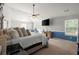 Open primary bedroom with a ceiling fan, a TV, and plenty of natural light at 423 Blackbird Way, Hampton, GA 30228