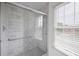 Tiled shower stall with glass door, chrome fixtures, and window with blinds at 1382 Benbrooke Nw Ln, Acworth, GA 30101