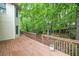 Wooden deck with railings offers views of the green, tree-filled backyard at 1382 Benbrooke Nw Ln, Acworth, GA 30101
