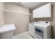Laundry room with white cabinets, open shelving, washer, dryer, and countertop at 1382 Benbrooke Nw Ln, Acworth, GA 30101