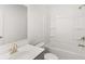 Bright bathroom featuring white vanity with sink, gold faucet, mirror and bathtub with shower at 1831 Lacebark Elm Way, Lawrenceville, GA 30045