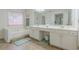 Well-lit bathroom with dual sinks, white cabinets, a soaking tub, and tile flooring at 2022 Maple Ridge Nw Dr, Acworth, GA 30101