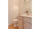 Well-lit half bathroom with light pink cabinets and a hardwood floor at 2022 Maple Ridge Nw Dr, Acworth, GA 30101