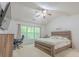 Bedroom with neutral carpet, a ceiling fan, and a large window bringing in natural light at 2022 Maple Ridge Nw Dr, Acworth, GA 30101