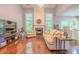Open living room with hardwood floors, large windows, a fireplace, and an entertainment center at 2022 Maple Ridge Nw Dr, Acworth, GA 30101