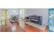 Open-concept living room with gleaming hardwood floors, natural light, features dining area and piano at 2022 Maple Ridge Nw Dr, Acworth, GA 30101