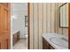 Vintage bathroom with patterned wallpaper, a classic vanity, and decorative mirror at 61 Sherwood Se Ln, Marietta, GA 30067
