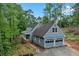 Charming home with attached garage and covered porch surrounded by mature trees on a sunny day at 61 Sherwood Se Ln, Marietta, GA 30067