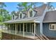 View of a cozy porch with white railings, dormer windows, and wood detailing on a sunny day at 61 Sherwood Se Ln, Marietta, GA 30067