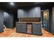 Basement bar area featuring custom cabinets, a wood countertop, and a beverage refrigerator for entertaining at 305 Montevallo Dr, Atlanta, GA 30342