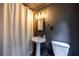 Bathroom featuring a single vanity sink, toilet, and a shower with dark gray walls and modern lighting at 305 Montevallo Dr, Atlanta, GA 30342