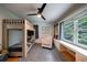 Bright bedroom featuring bunk beds, a ceiling fan, and a window offering views of a lush, green landscape at 305 Montevallo Dr, Atlanta, GA 30342
