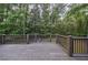 View of the wooden deck surrounded by a lush, wooded backyard, great for enjoying the outdoors at 305 Montevallo Dr, Atlanta, GA 30342