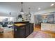 Bright open kitchen with modern appliances, dark island, and hardwood floors adjacent to the living room and dining area at 305 Montevallo Dr, Atlanta, GA 30342