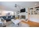 Cozy living room featuring a fireplace, built-in shelves, and hardwood floors at 305 Montevallo Dr, Atlanta, GA 30342
