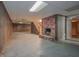 Unfinished basement with brick fireplace, wood paneled walls, drop ceiling, and concrete floor at 3916 Ridgewood Se Dr, Smyrna, GA 30080