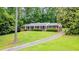 The home has a sprawling front lawn and a brick exterior with black shutters and white columns at 3916 Ridgewood Se Dr, Smyrna, GA 30080