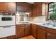 Close up of the kitchen with wood cabinets, white countertops and appliances, and hardwood floors at 3916 Ridgewood Se Dr, Smyrna, GA 30080